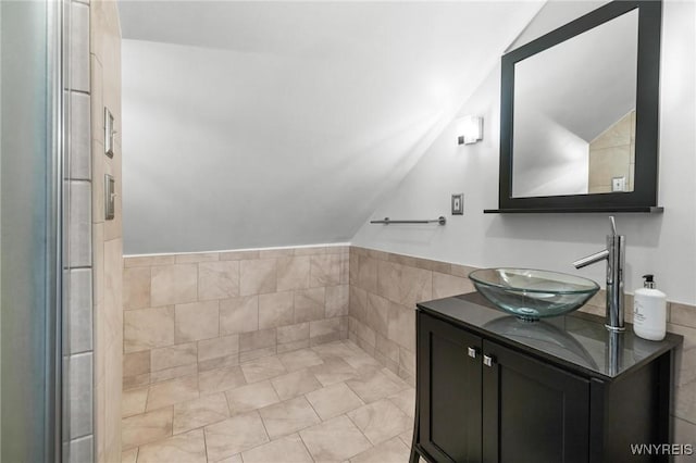 bathroom featuring vanity, lofted ceiling, and tile patterned floors