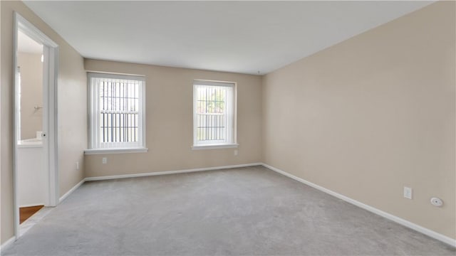 carpeted empty room featuring baseboards