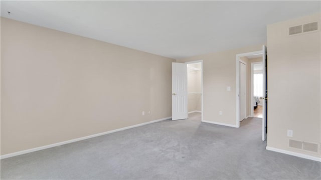 unfurnished bedroom with baseboards, carpet, a walk in closet, and a closet