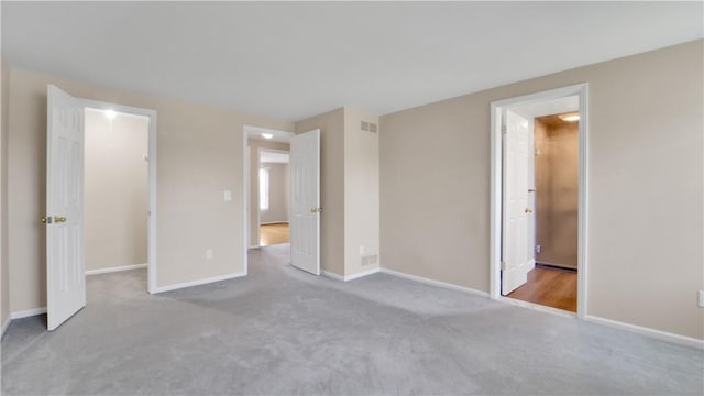 unfurnished bedroom featuring carpet floors, baseboards, and a spacious closet
