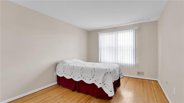 bedroom with wood finished floors and baseboards