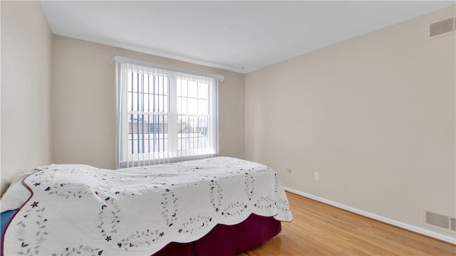 bedroom featuring light wood-style floors and baseboards