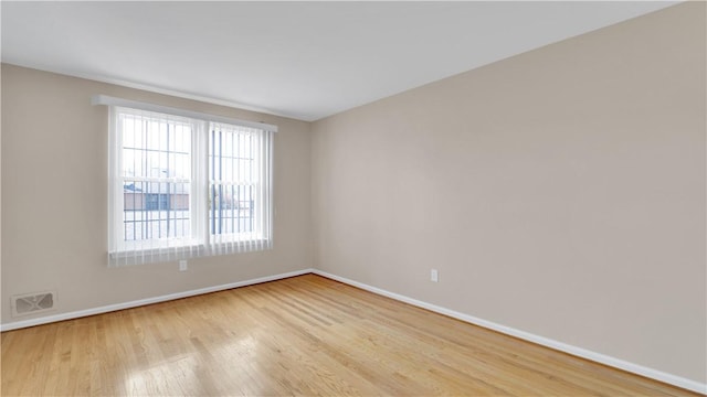 unfurnished room with baseboards and light wood-style floors