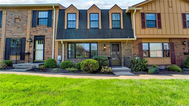 multi unit property with brick siding and a front lawn