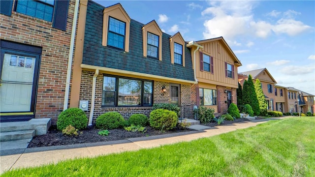 multi unit property with brick siding, board and batten siding, a front lawn, and a residential view