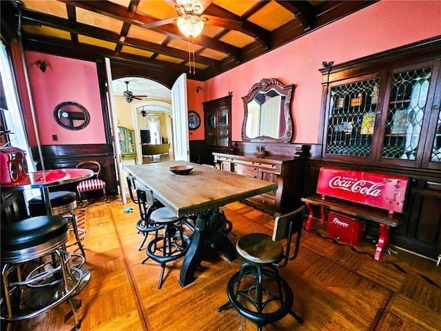 440 Park Ave, Barton, NY 14892 - dining area with ceiling fan, coffered ceiling, arched walkways, beam ceiling, and a wainscoted wall