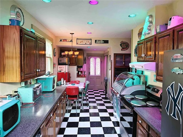 440 Park Ave, Barton, NY 14892 - kitchen with appliances with stainless steel finishes, dark flooring, dark countertops, a chandelier, and decorative light fixtures