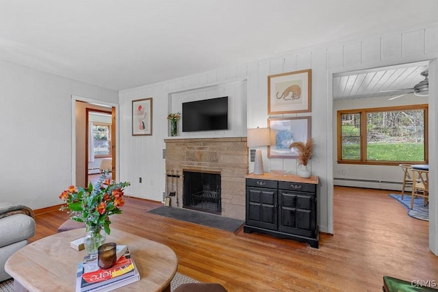 10 S Ten Eyck Ave, Cazenovia, NY 13035 - living area featuring baseboard heating, wood finished floors, a fireplace, a baseboard radiator, and a ceiling fan