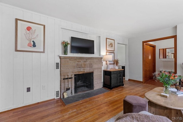 10 S Ten Eyck Ave, Cazenovia, NY 13035 - living area with wood finished floors, a stone fireplace, and baseboards
