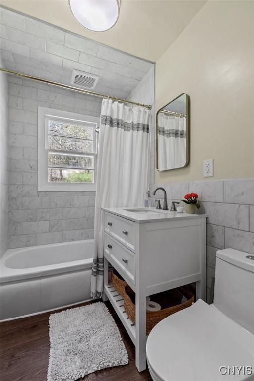 10 S Ten Eyck Ave, Cazenovia, NY 13035 - full bath with toilet, wood finished floors, vanity, tile walls, and shower / bath combo