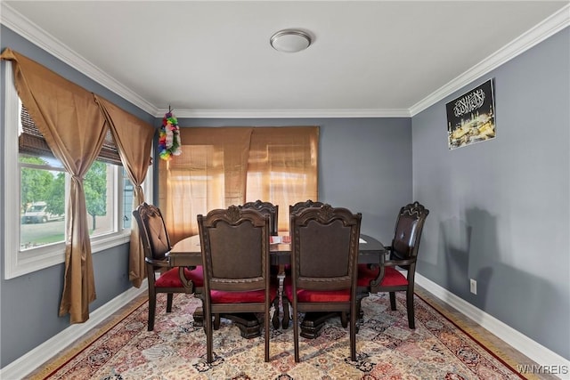 dining area with ornamental molding, baseboards, and wood finished floors