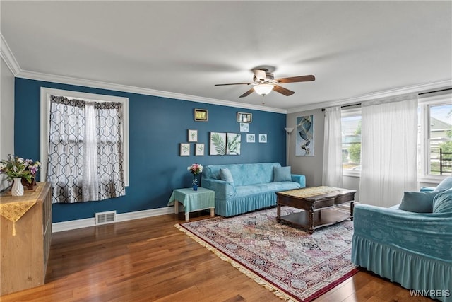 living area featuring a ceiling fan, ornamental molding, wood finished floors, and baseboards