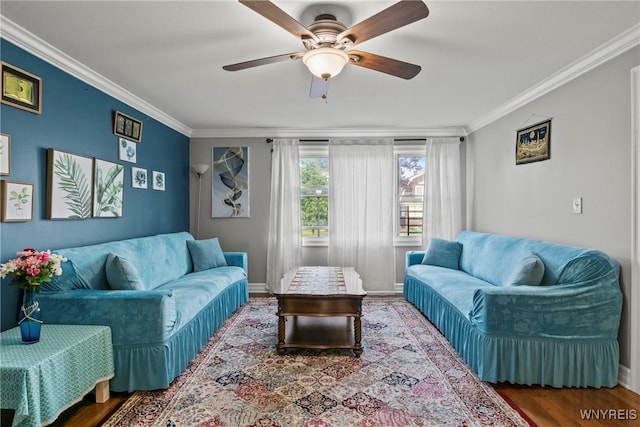 living area with ornamental molding, a ceiling fan, wood finished floors, and baseboards