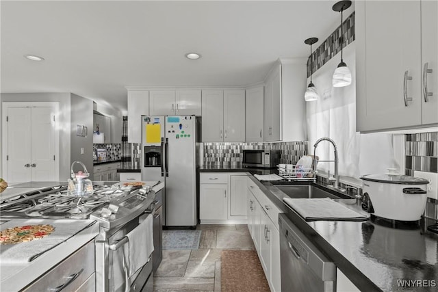 kitchen with appliances with stainless steel finishes, a sink, backsplash, white cabinetry, and recessed lighting