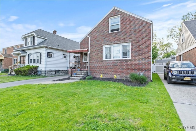 view of front of home featuring brick siding and a front lawn