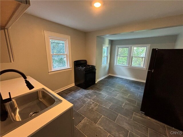 214 Herriman St Unit 216, Syracuse, NY 13204 - kitchen featuring black appliances, a sink, baseboards, and dark stone finish flooring