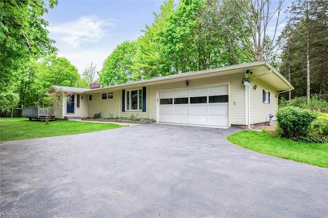 single story home featuring driveway, a garage, a front yard, and a chimney