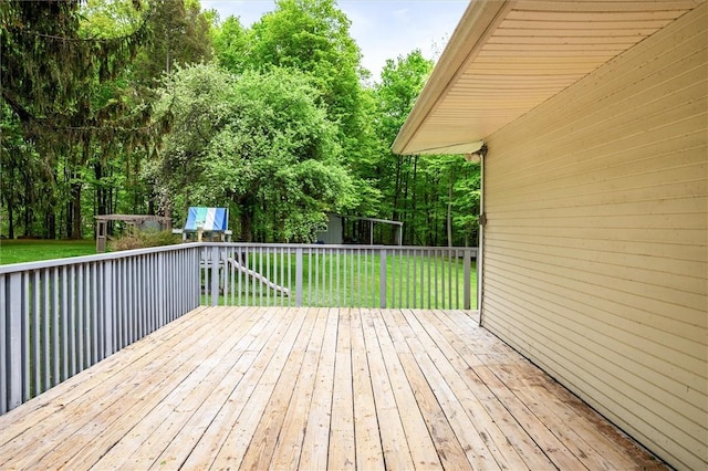 deck with a yard, an outdoor structure, a storage unit, and view of scattered trees