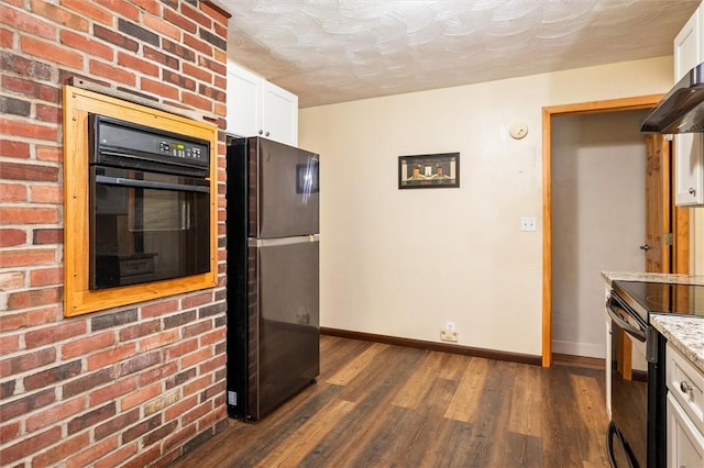 kitchen with black appliances, baseboards, dark wood-type flooring, white cabinetry, and light stone counters