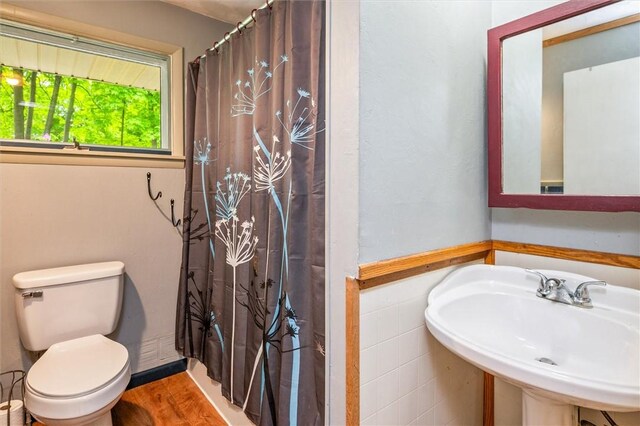 bathroom featuring a sink, toilet, a shower with shower curtain, and wood finished floors