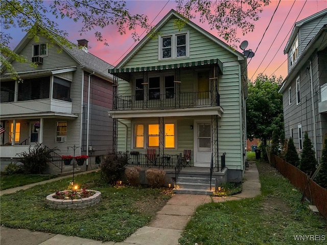 2254 Grand Ave, Niagara Falls, NY 14301 - view of front facade with covered porch, a balcony, an outdoor fire pit, and fence