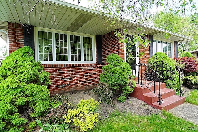 doorway to property featuring brick siding