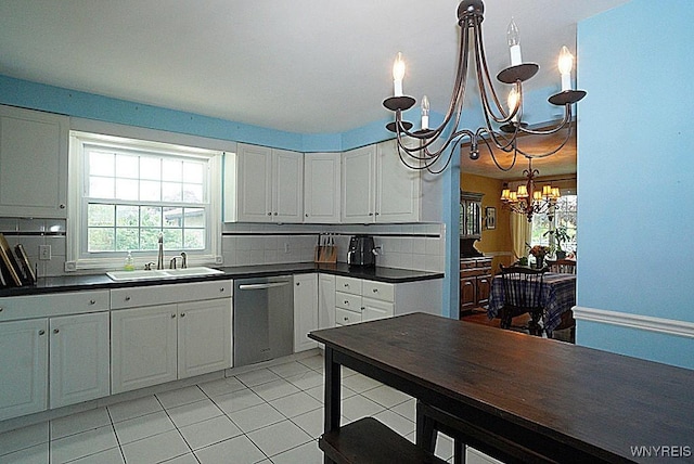 kitchen featuring a sink, a chandelier, stainless steel dishwasher, and dark countertops