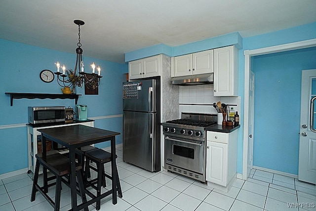 kitchen featuring appliances with stainless steel finishes, under cabinet range hood, a chandelier, tasteful backsplash, and white cabinets