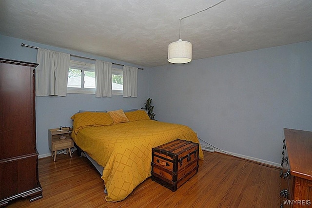 bedroom featuring wood finished floors and baseboards