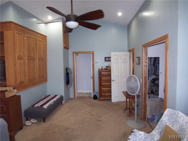 carpeted bedroom with a towering ceiling and a ceiling fan