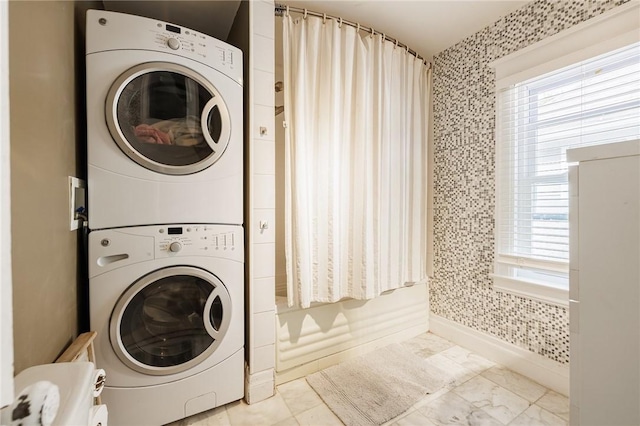 141 Mulberry St, Rochester, NY 14620 - laundry area with estacked washer and dryer, baseboards, and marble look tile flooring