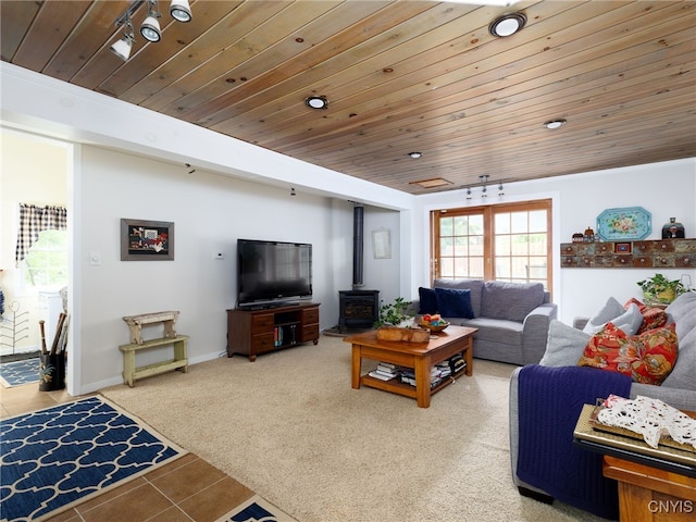 127 W St, Rutland, NY 13612 - carpeted living room featuring a wood stove, wooden ceiling, and tile patterned flooring