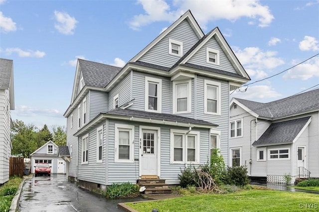 119 Charles Ave, Geddes, NY 13209 - view of front of property featuring entry steps, an outdoor structure, a detached garage, a shingled roof, and a front lawn