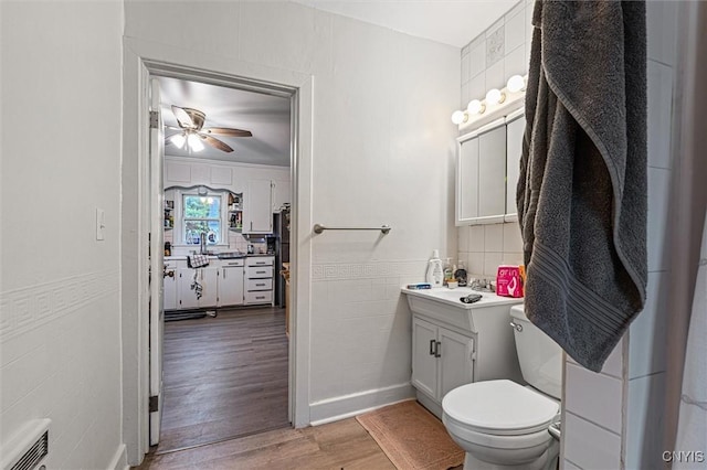 119 Charles Ave, Geddes, NY 13209 - half bath with wood finished floors, vanity, a ceiling fan, toilet, and backsplash