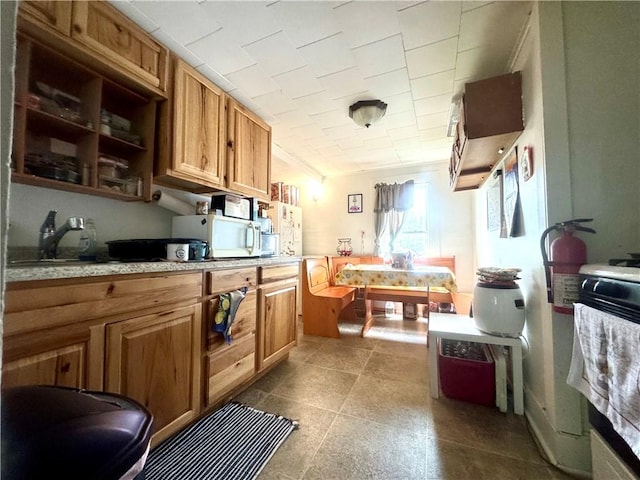 11 Gilbert St, Oneonta-City, NY 13820 - kitchen with white microwave, light countertops, crown molding, brown cabinets, and open shelves