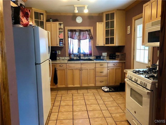 136 Charles St, Watertown-City, NY 13601 - kitchen featuring white appliances, a sink, tile counters, light tile patterned floors, and glass insert cabinets