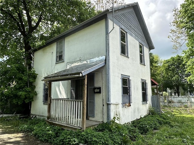 313 W 4th St, Elmira-City, NY 14901 - rear view of house with stucco siding and fence