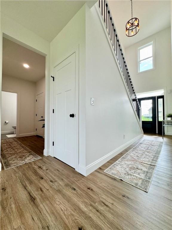 4 Brookwood Hills Dr, Big Flats, NY 14845 - entrance foyer featuring stairs, wood finished floors, a chandelier, baseboards, and a high ceiling