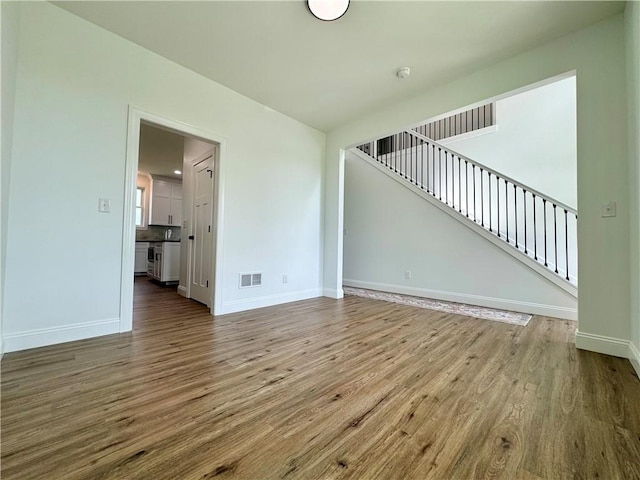 4 Brookwood Hills Dr, Big Flats, NY 14845 - unfurnished living room featuring wood finished floors, baseboards, and stairway