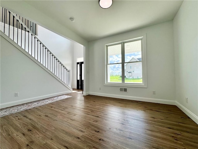 4 Brookwood Hills Dr, Big Flats, NY 14845 - unfurnished living room featuring baseboards, dark wood-type flooring, and stairs