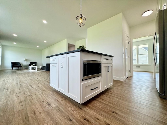 4 Brookwood Hills Dr, Big Flats, NY 14845 - kitchen with wood finished floors, freestanding refrigerator, stainless steel microwave, baseboards, and white cabinets