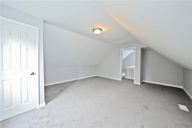 additional living space with carpet, lofted ceiling, and baseboards