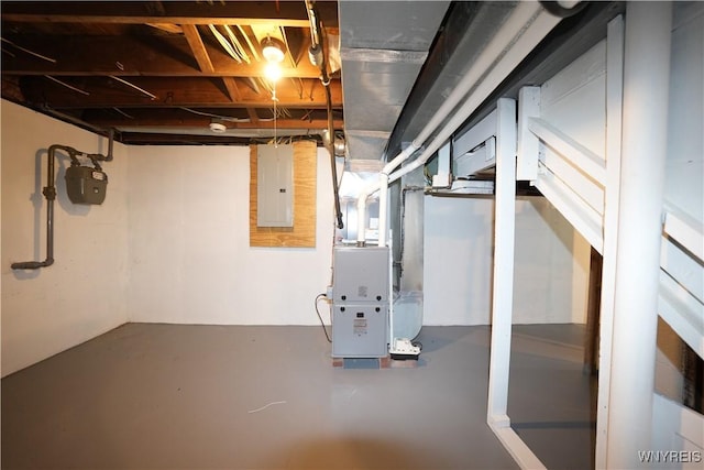 unfinished below grade area with gas meter, electric panel, and heating unit