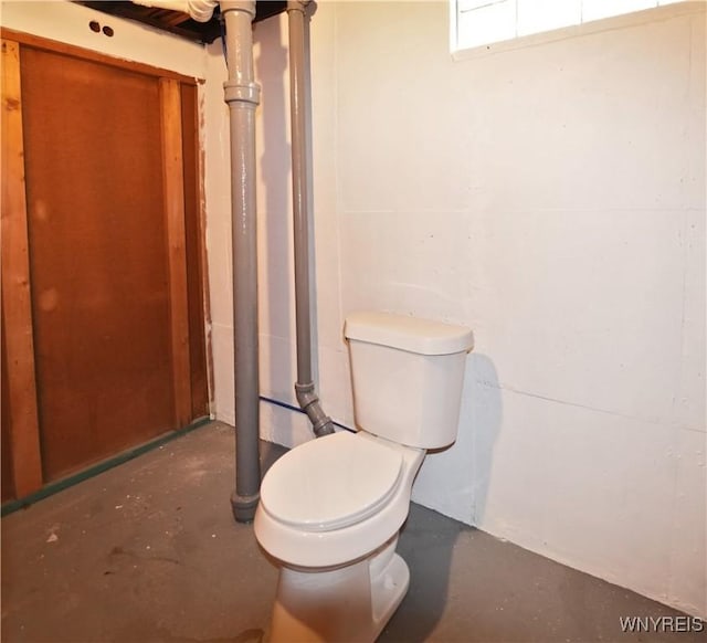 bathroom featuring concrete flooring and toilet