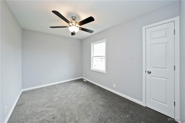 unfurnished room featuring dark carpet, ceiling fan, and baseboards