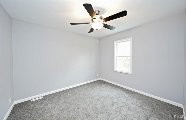 carpeted empty room featuring baseboards and a ceiling fan