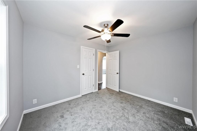 unfurnished bedroom featuring carpet floors, baseboards, and ceiling fan