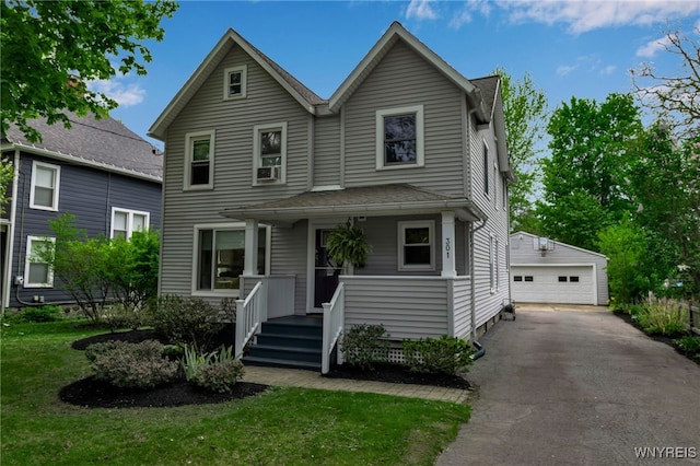 traditional-style house with an outdoor structure, a garage, a front yard, and covered porch