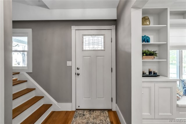 foyer entrance featuring wood finished floors and stairway
