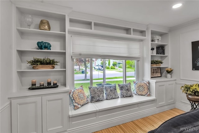 detailed view of wood finished floors, built in features, and crown molding